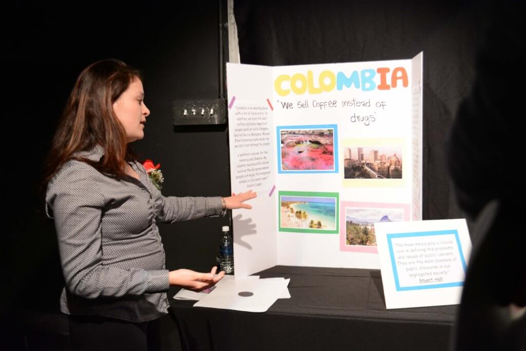 Paula Moreno presenting her poster to counter stereotypes about Colombia.