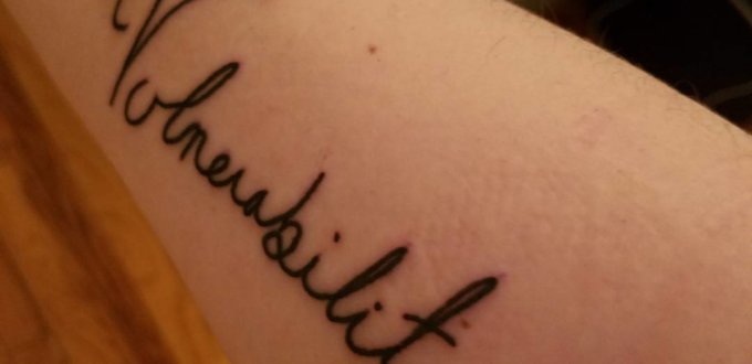 The word "Vulnerability", written in cursive, tattooed on the author's forearm.